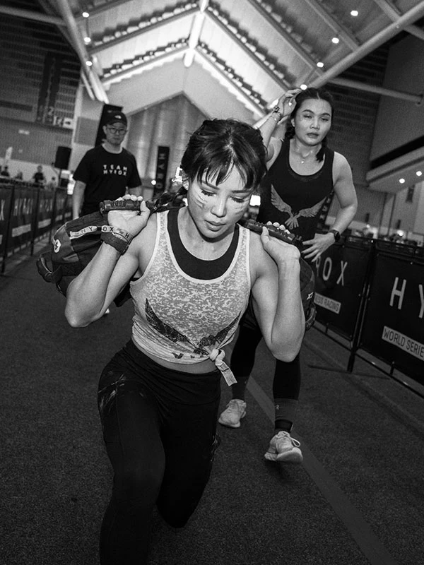Eine Gruppe von Frauen machen Ausfallschritte mit Zusatzgewicht bei HYROX x Zone.Fit