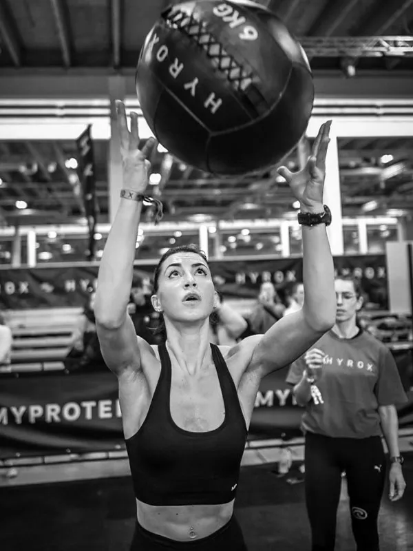 Frau mit Medball HYROX x Zone.Fit